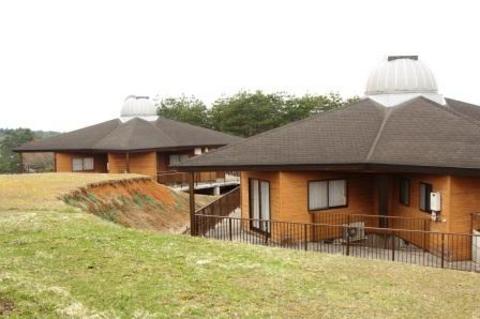手前に芝生が広がり、屋根の頂上がドーム型になっているコテージが2棟並んだ写真