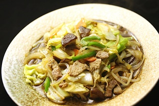 いしりを使って料理された、野菜炒めが丸皿に盛られている写真