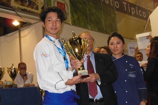 トロフィーを受け取り横を向いた柴野大造さんの写真