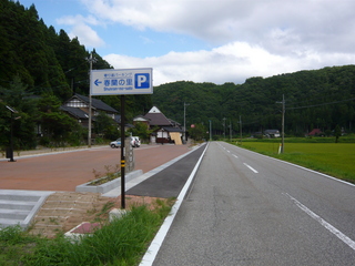 道路沿いに設置された「春蘭の里」と書かれた駐車場の看板の写真