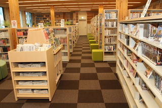 沢山の本が並んだ本棚が部屋の奥まで続いている図書館の写真