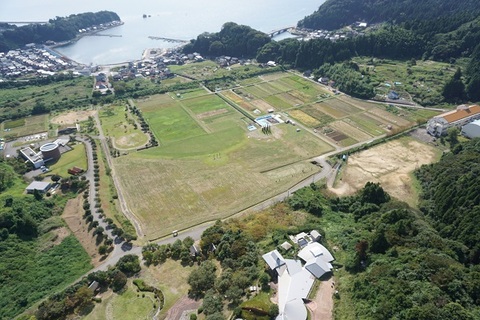 奥に海が広がり、緑の自然溢れる国指定史跡 真脇遺跡の航空写真