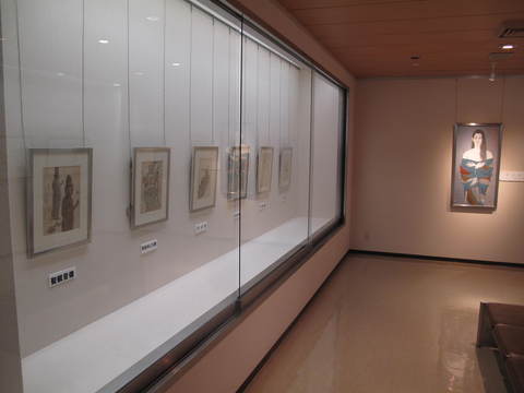 額に入った作品がガラスケースに展示されている1階展示室の写真