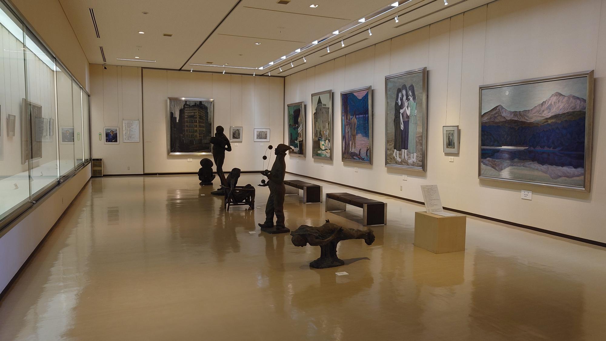 額に入った絵の作品が壁に横並びに掲示された様子の写真
