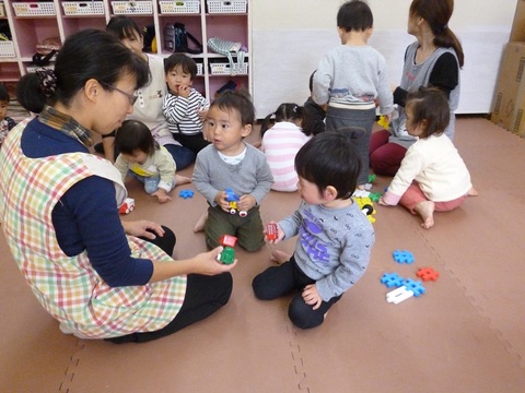 それぞれ3人の先生のそばに集まって遊んでいる園児たちの写真